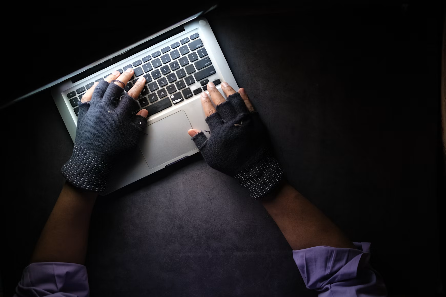 Hacker sitzt vor Laptop und klaut Daten